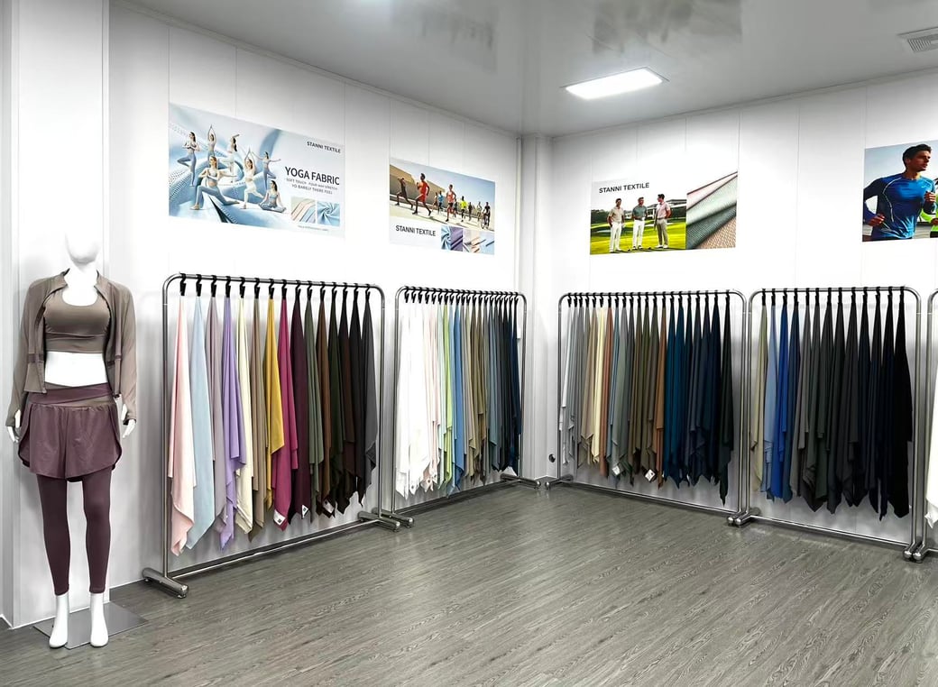 STANNI TEXTILE showroom with a mannequin and racks of hanging fabric samples